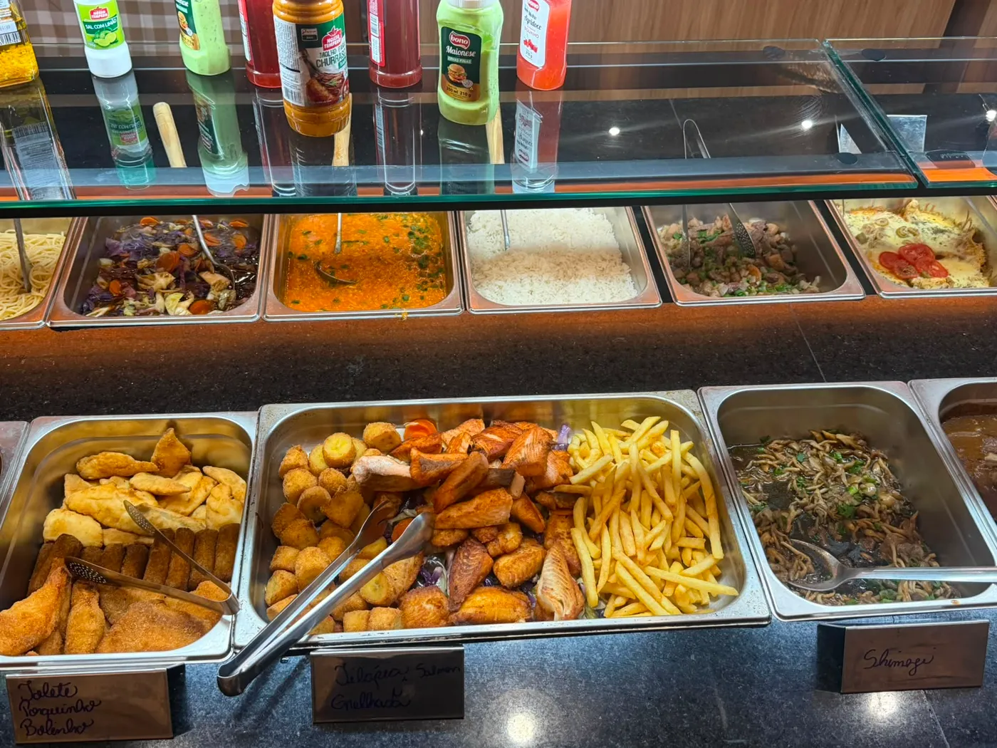 Cubas do buffet com pratos quentes, guarnições e porções variadas