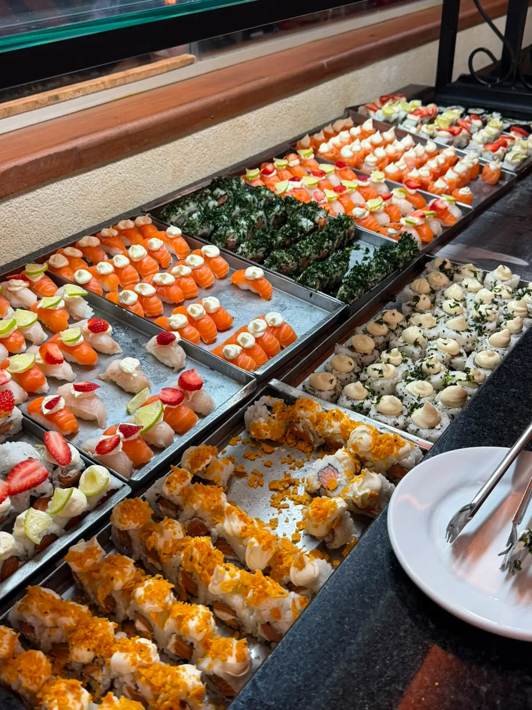 Bandejas de sushi, niguiris de salmão e hot rolls no buffet do Marina Sabores