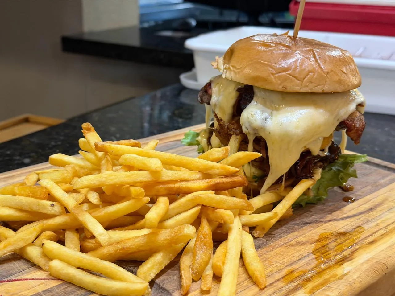 Hambúrguer artesanal — Hambúrguer com queijo derretido e fritas na tábua